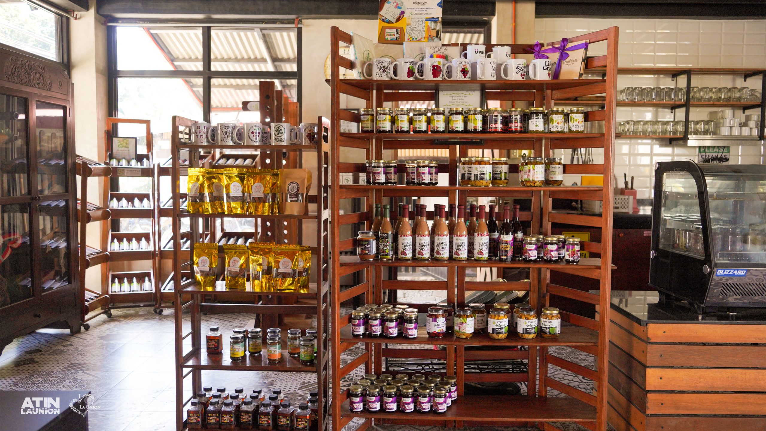 A cabinet with different souvenir items such as grape sauces and guapple sarsa.